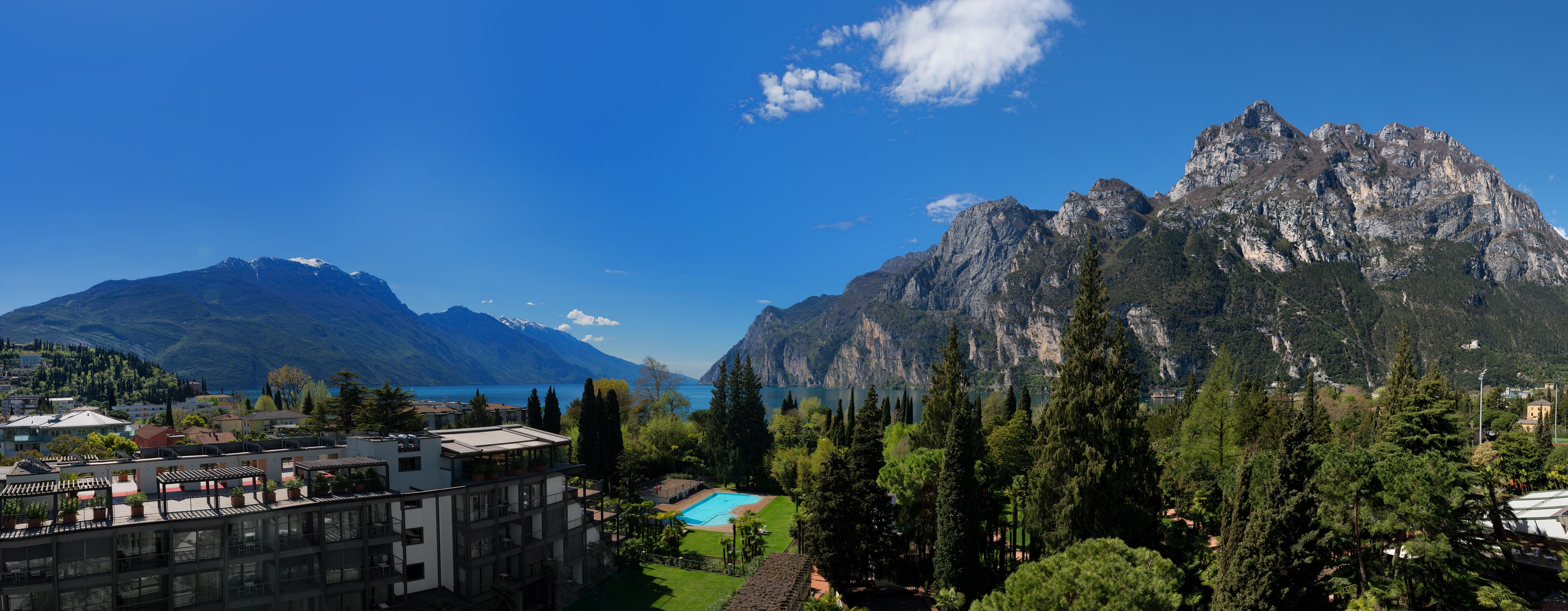 Un hotel con piscina, vistas a la montaña y un lago.