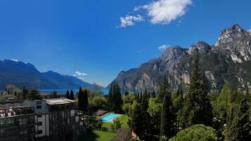 Un hotel con piscina, vistas a la montaña y un lago.
