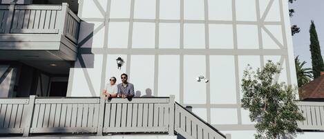 Un bâtiment à la façade blanche et doté d’un balcon avec des balustrades.