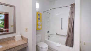A bathroom with a toilet, sink, mirror, shower, and bathtub. - Motel 6 Seaford, DE (Seaford)