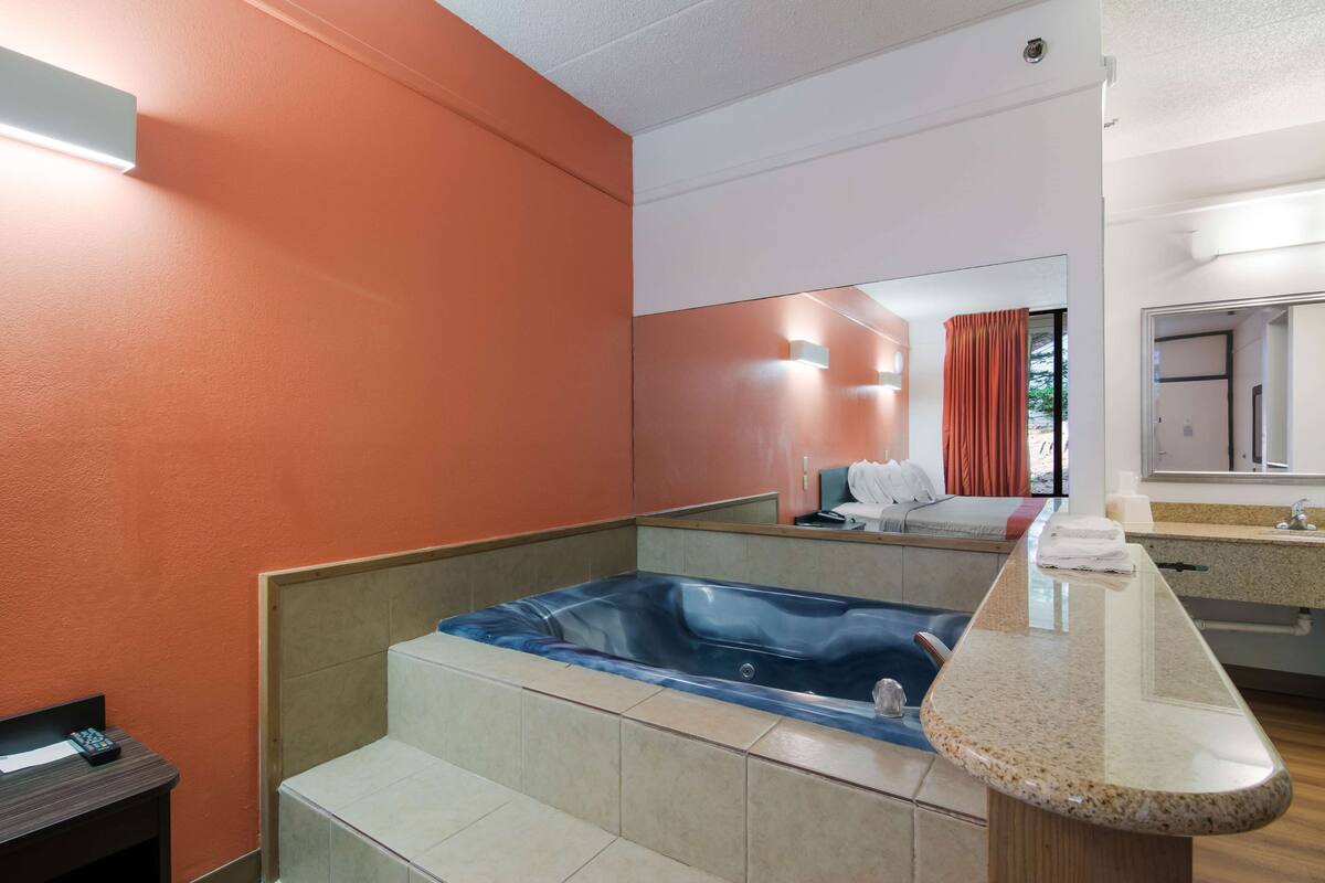 A modern bathroom with a large bathtub, a vanity with a mirror, and a shower area.
