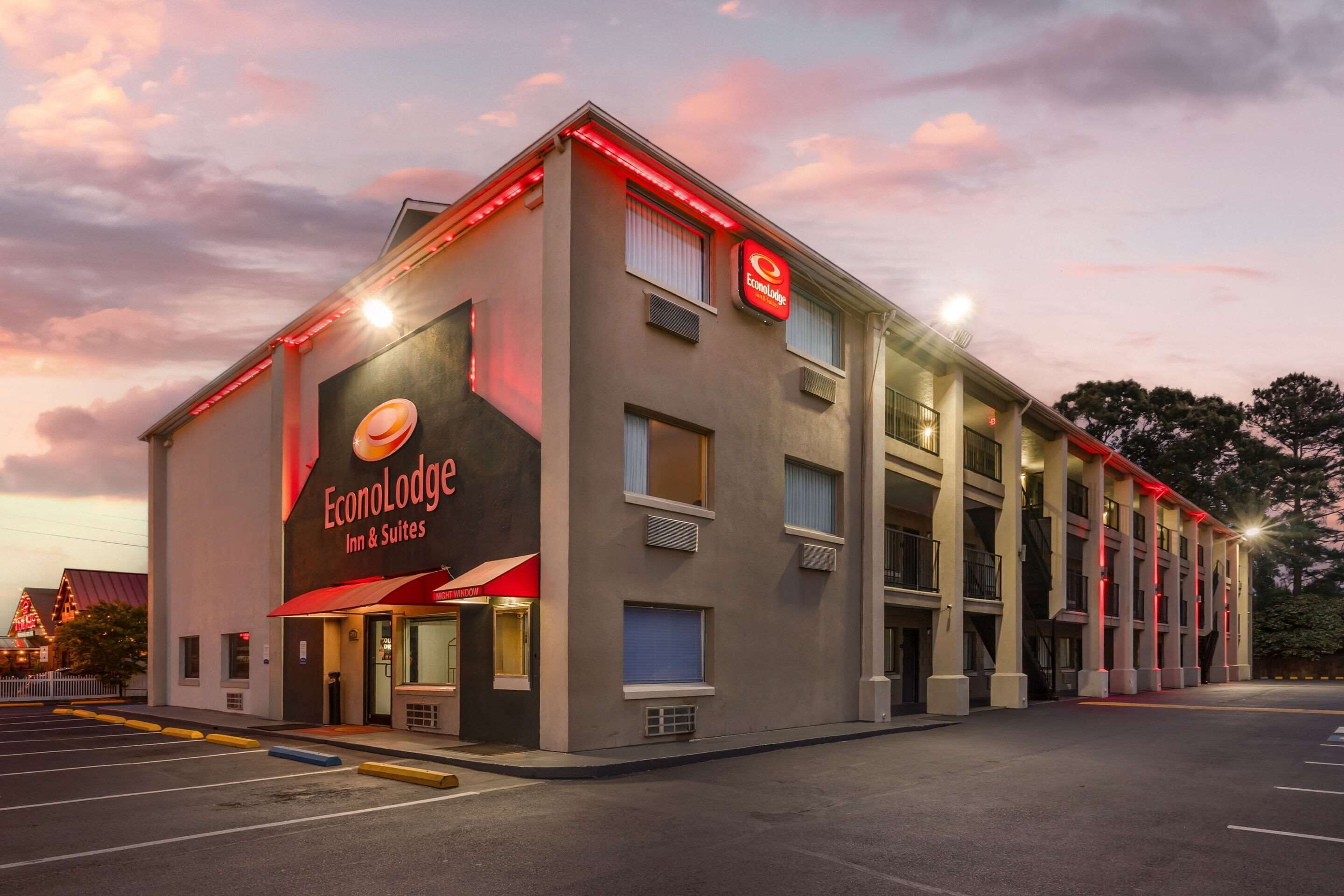 Un hotel chiamato EconoLodge Inn & Suites, dal design moderno, con un cartello ben visibile e un parcheggio.