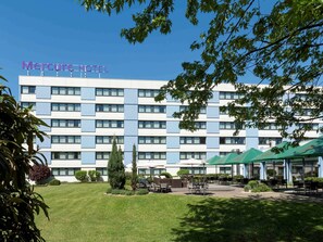 Enjoy the hotel's outdoor seating area with tables and chairs.
