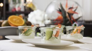 A table with clear glass cups containing a layered dessert, surrounded by white plates. - Mercure Hotel Mannheim am Friedensplatz (Mannheim)