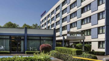 Een modern hotelgebouw met een bord waarop “Mercure Hotel” staat.