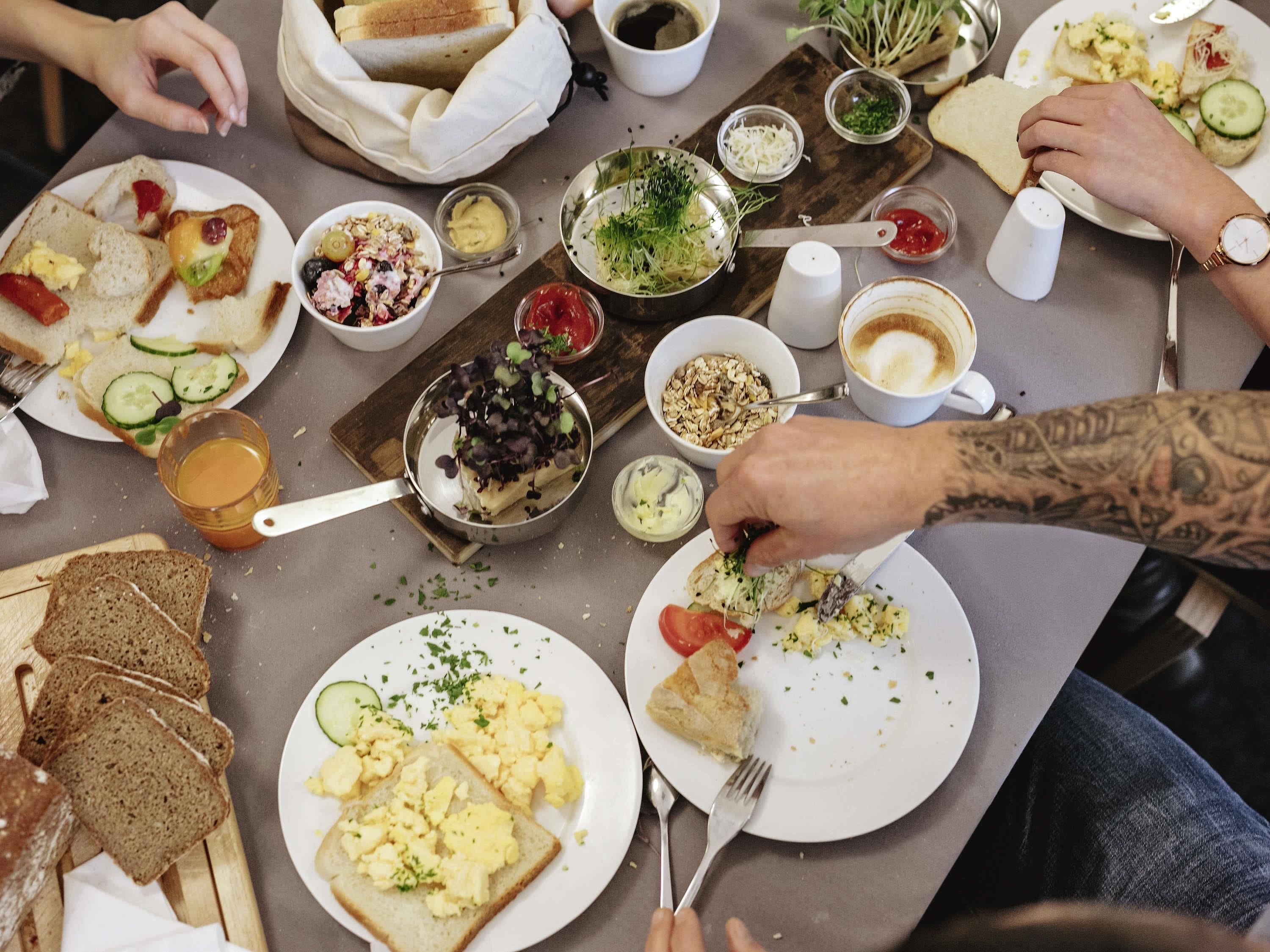 A dining table with various food items and utensils.