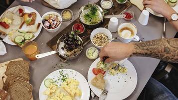 A dining table with various food items and utensils.