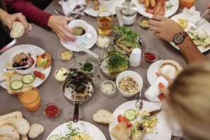 Enjoy a communal dining experience with a beautifully set table featuring a variety of dishes and utensils.