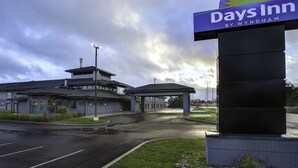 A Days Inn by Wyndham hotel with a modern design, a covered parking area, and a large sign.