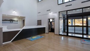 A modern reception area with a reception desk, a large window, and a vending machine.