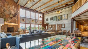 A spacious lobby with a large glass coffee table displaying various fabrics, a stone fireplace, and a mounted elk head. - Comfort Inn Flagstaff South I-17 (Flagstaff)