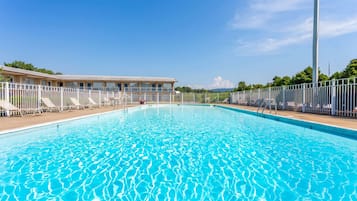 Una piscina al aire libre de temporada, sombrillas