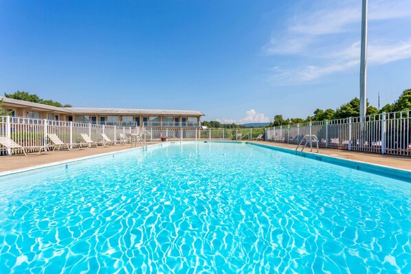 Una piscina al aire libre de temporada, sombrillas, tumbonas