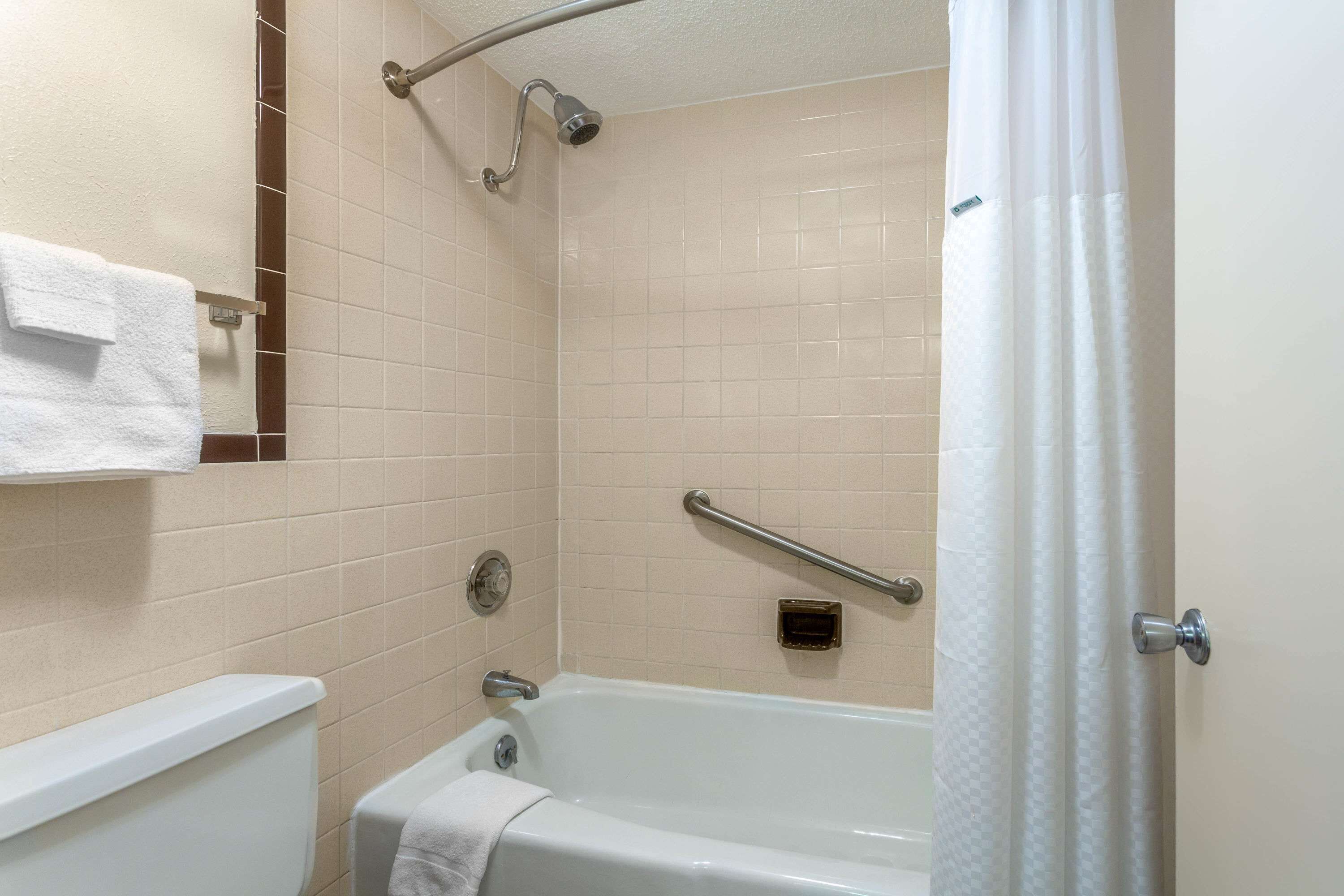 A bathroom with a bathtub, a shower, a toilet, and a towel rack.