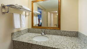 Une salle de bain avec un lavabo en granit, un miroir avec un cadre doré et un porte-serviettes avec deux serviettes.