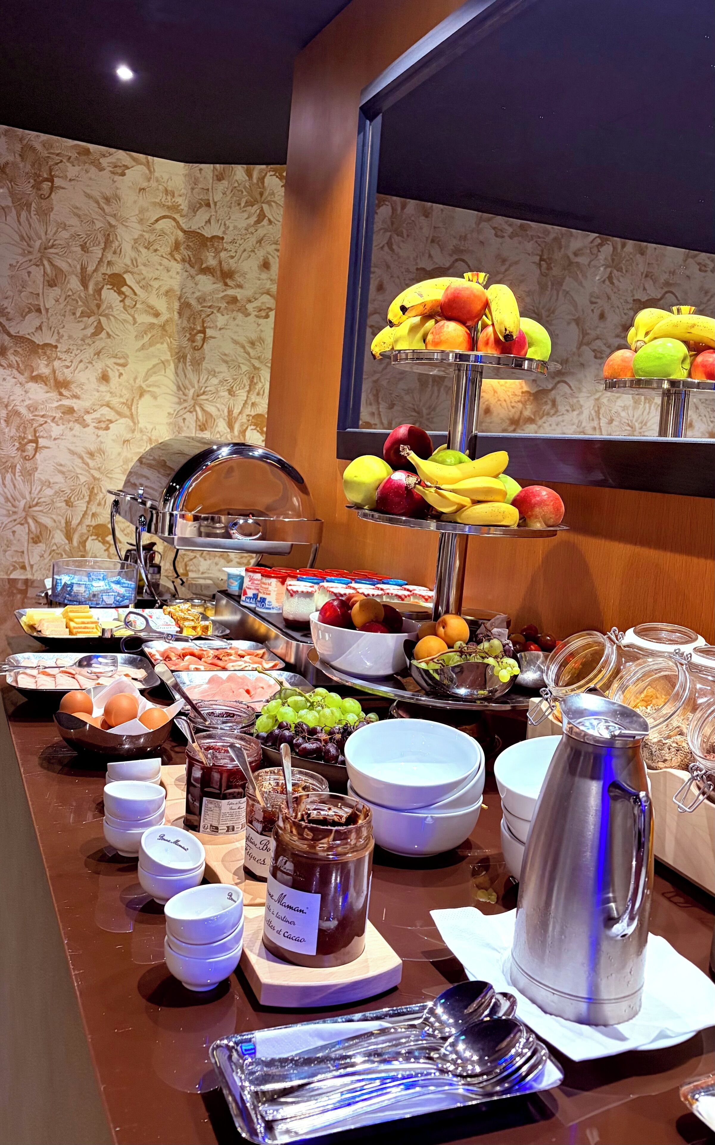 A buffet with various food items including fruits, meats, and condiments.