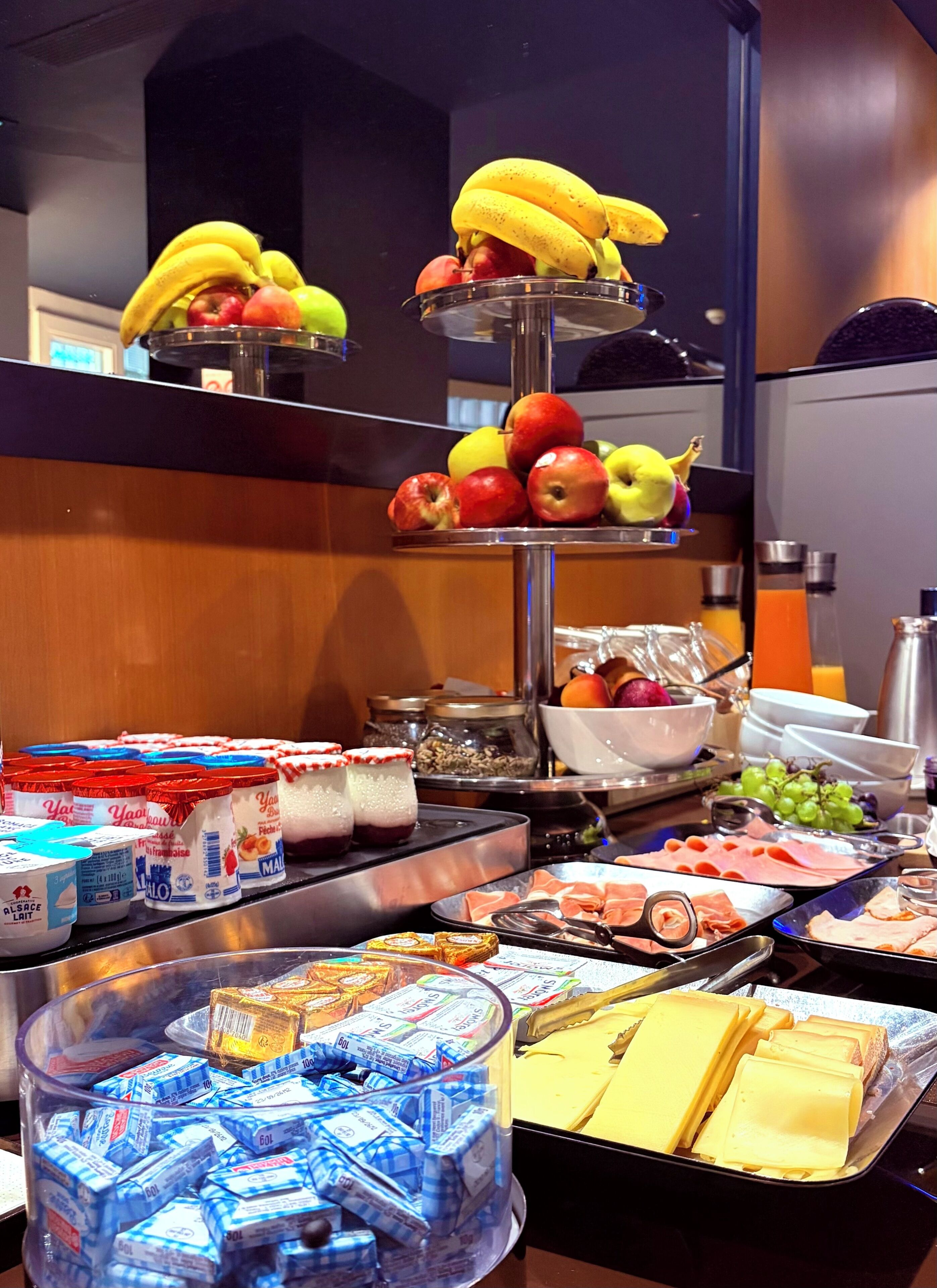 Ein reichhaltiges Buffet mit verschiedenen Speisen, darunter Obst, Käse und Fleisch.