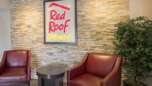 A Red Roof Plus lounge area with two leather armchairs and a small round table. - Red Roof Inn PLUS+ Boston - Framingham (Framingham)