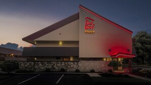 A hotel with a prominent sign reading 'Red Roof Plus' and a stone facade. - Red Roof Inn PLUS+ Boston - Framingham (Framingham)