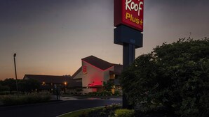 A Red Roof Plus hotel with a prominent sign, a modern building facade, and a well-maintained garden area. - Red Roof Inn PLUS+ Boston - Framingham (Framingham)