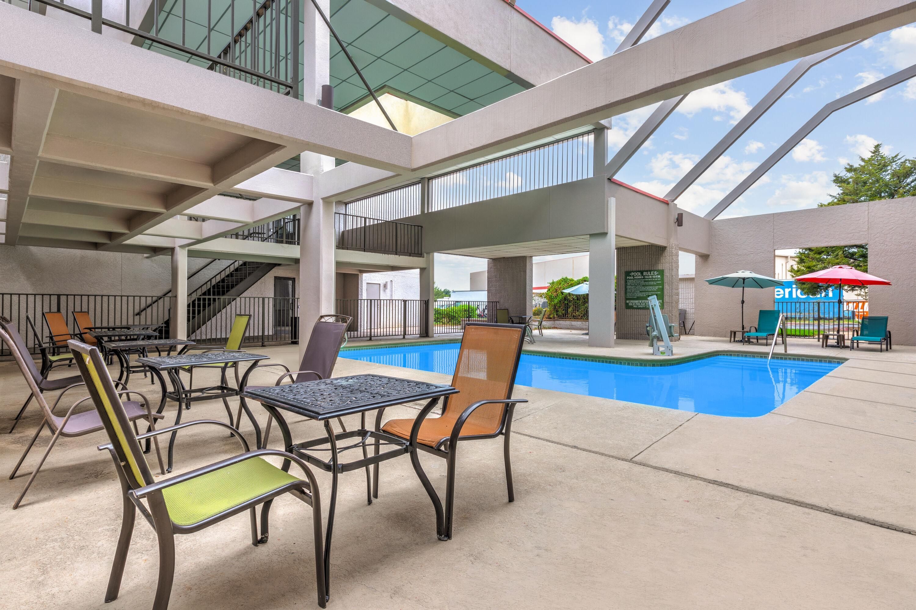 Un área de piscina interior con diversas opciones de asientos y una vista despejada a la piscina.