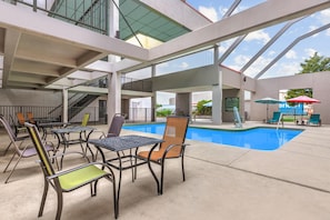 An indoor pool area with multiple seating arrangements and a clear view of the pool. - Ramada by Wyndham Tulsa Broken Arrow (Broken Arrow)