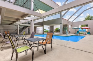Un área de piscina interior con diversas opciones de asientos y una vista despejada a la piscina.