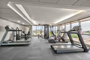 A gym with treadmills, weight machines, and a view of the outside. - Ramada by Wyndham Tulsa Broken Arrow (Broken Arrow)
