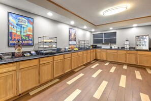 A spacious kitchen with wooden cabinets, a marble countertop, and various appliances. - Ramada by Wyndham Tulsa Broken Arrow (Broken Arrow)