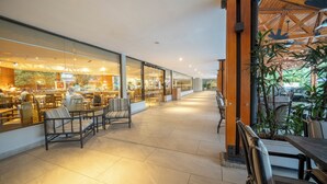 A spacious indoor area with seating arrangements and a view of a restaurant through glass walls.