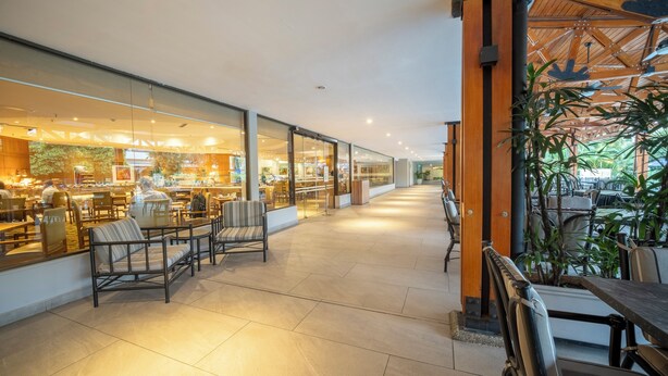 A spacious indoor area with seating arrangements and a view of a restaurant through glass walls. - InterContinental Cali by IHG (Cali)
