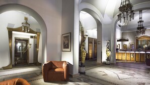 A spacious lobby with high ceilings, arched doorways, and a central seating area. - Hotel Paris Prague (Prague)