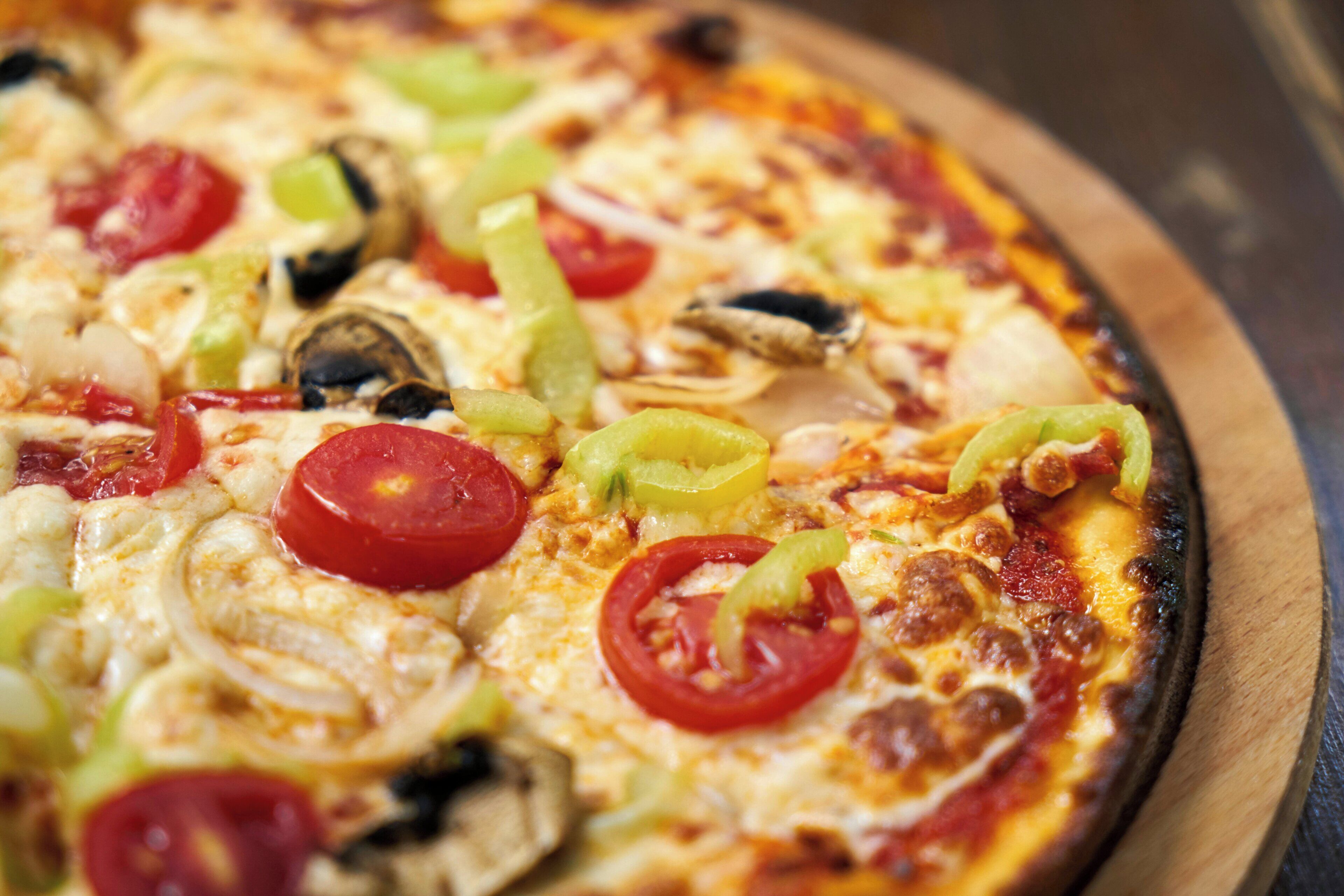 A pizza with various toppings on a wooden board.
