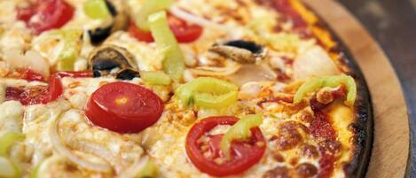Una pizza con diferentes ingredientes sobre una tabla de madera.