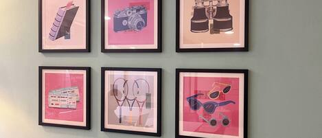 Six framed artworks on a wall.