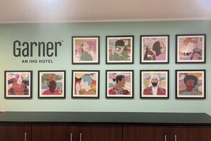 A wall with framed artwork and the text "Garnier AN IHG HOTEL".