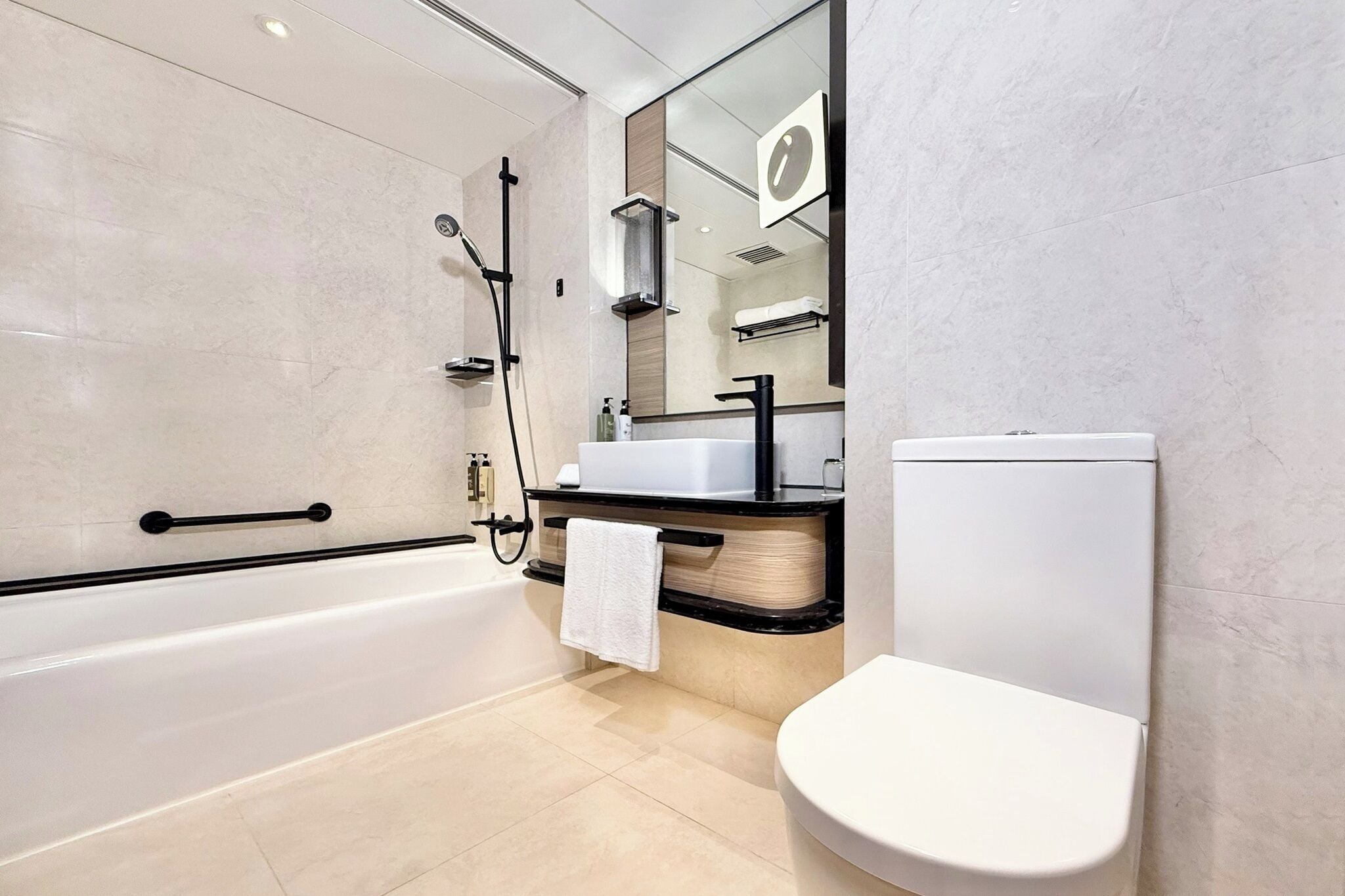 A modern bathroom with a bathtub, a sink, and a toilet.