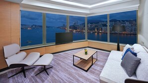 Una sala de estar moderna con vistas a la ciudad, un sofá, una mesa de centro y un televisor.