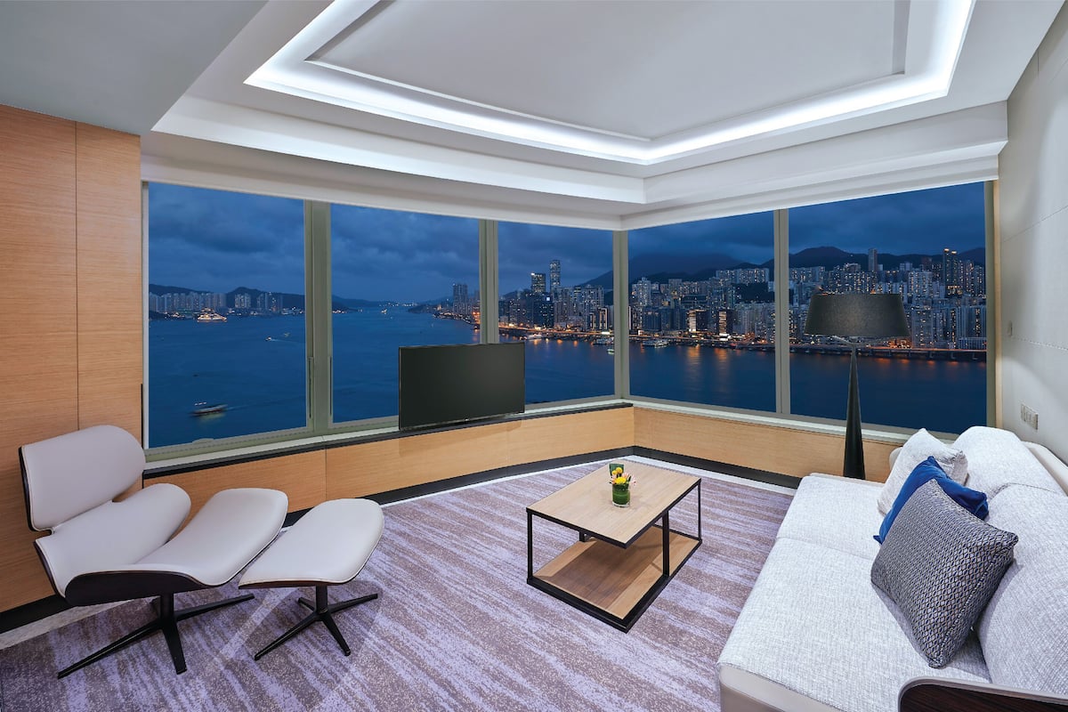 A modern living room with a city view, a sofa, a coffee table, and a TV.