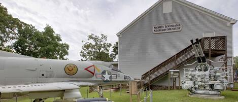Museo Militar del Norte de Luisiana con una aeronave militar y un cañón grande en exhibición.
