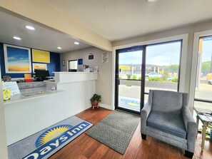 A reception area with a desk, computer, and a view of the parking lot through the glass door. - Days Inn by Wyndham Ruston LA (Ruston)