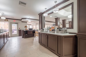 A hotel lobby with a reception desk, a large mirror, and a view of the outside. - Red Roof Inn PLUS+ & Suites Knoxville West-Cedar Bluff (Knoxville)