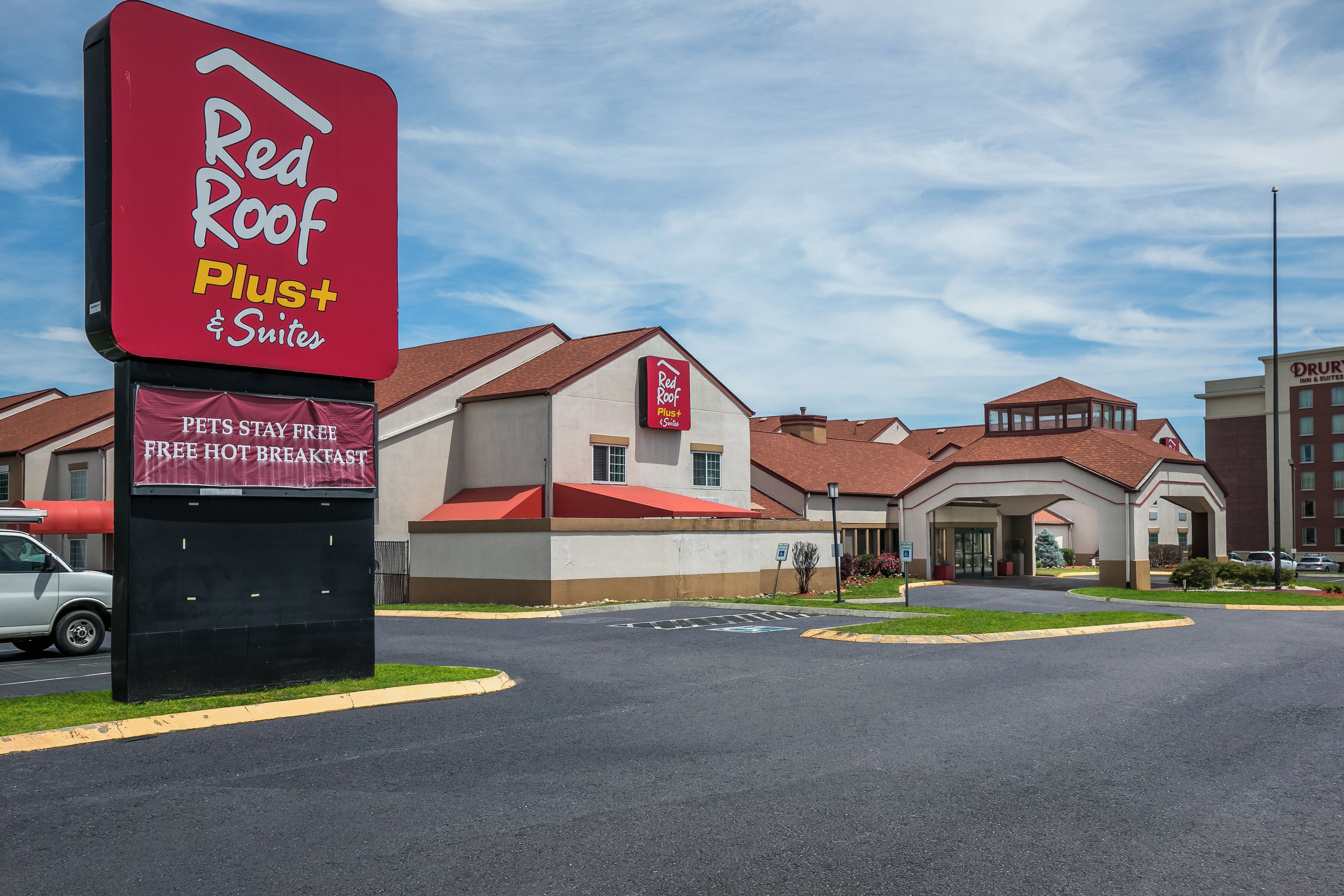 A Red Roof Plus Suites hotel with a clear sky.
