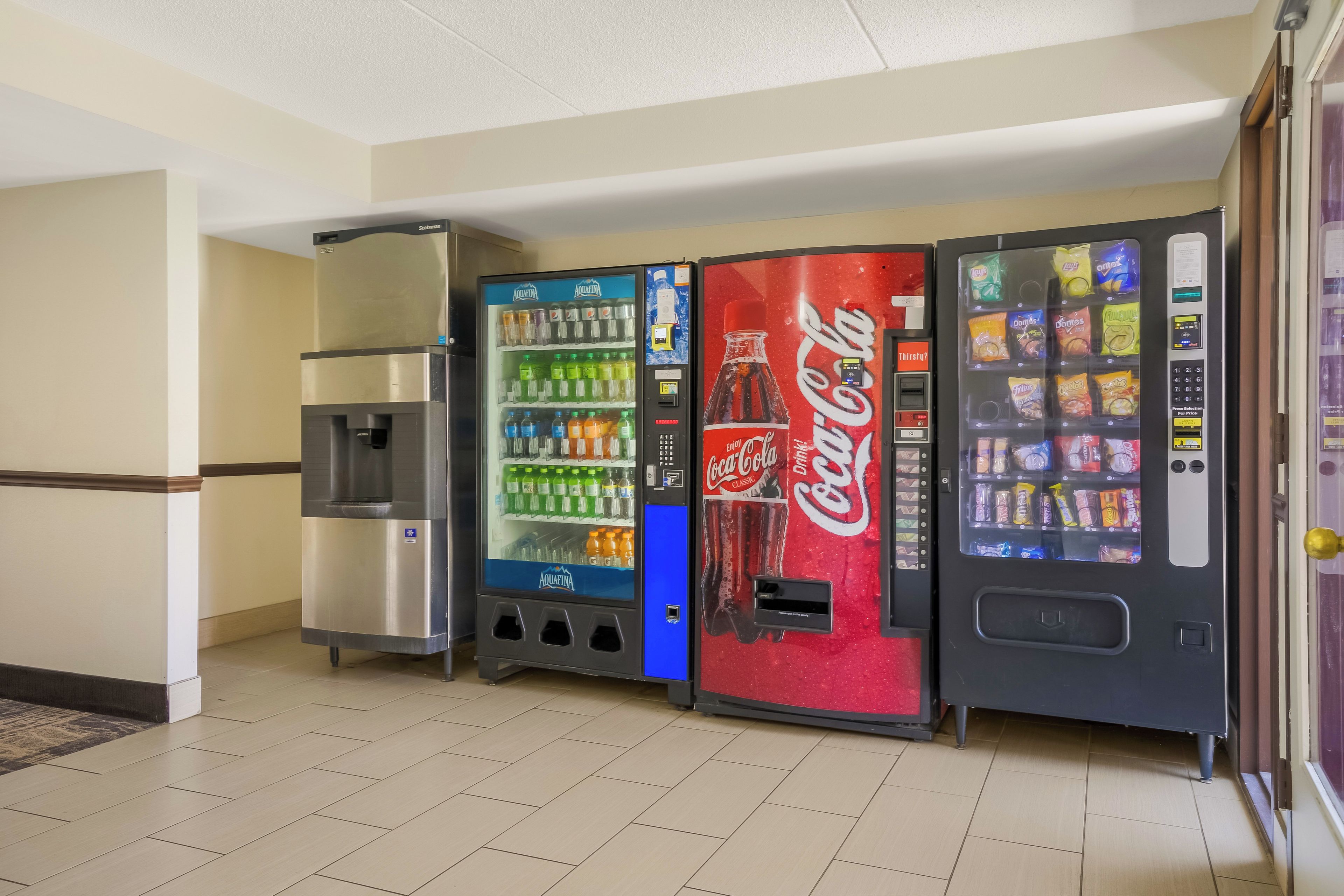 Una fila di distributori automatici con diverse bevande e snack.