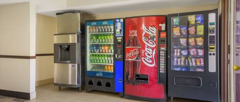 Una fila di distributori automatici con diverse bevande e snack.