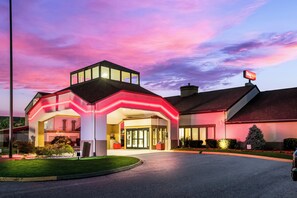 A hotel with a modern design, featuring a prominent entrance with glass doors and a flat roof.