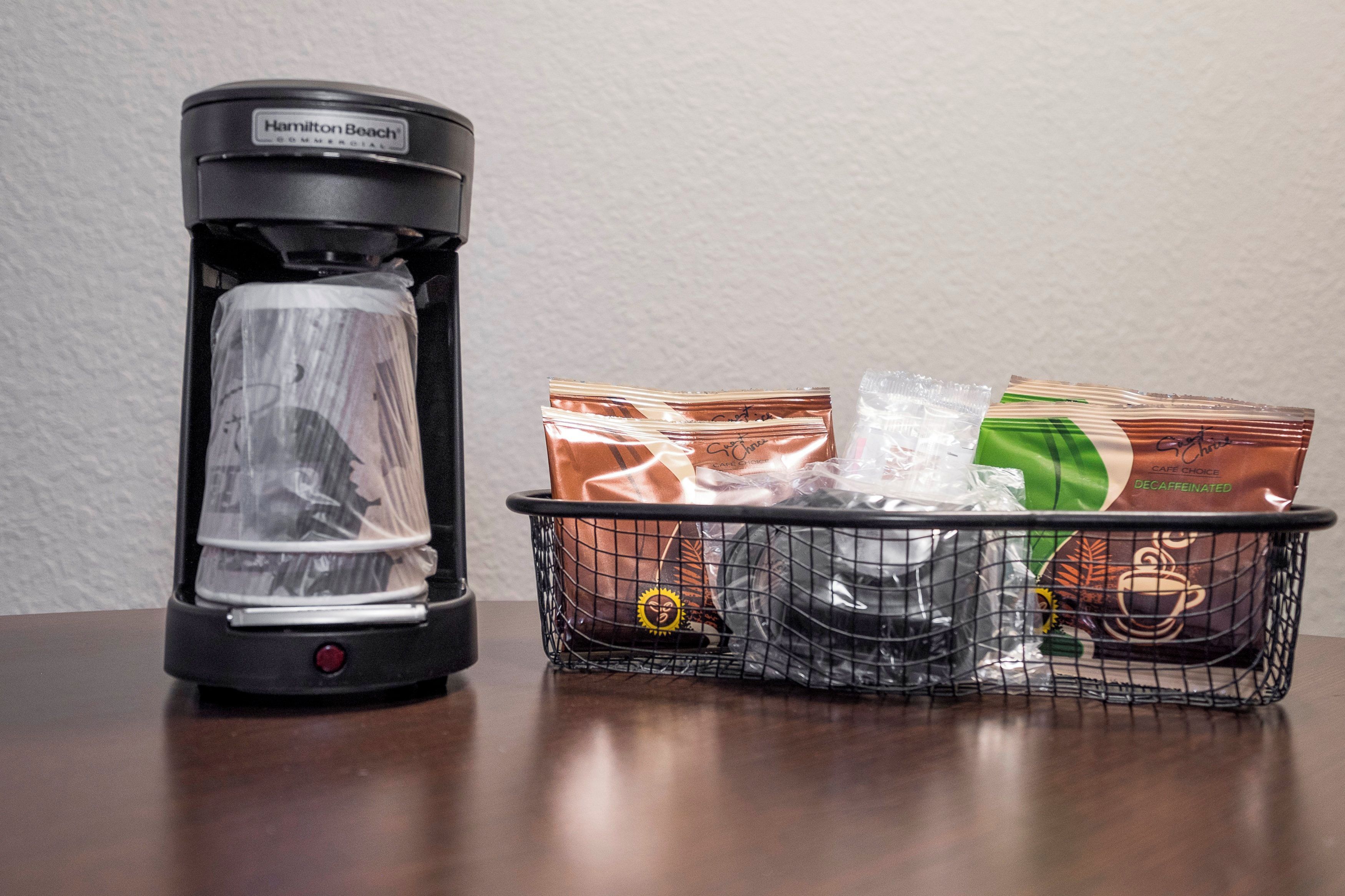 Een Hamilton Beach koffiezetapparaat voor commercieel gebruik en een mand met cafeïnevrije koffiecups en een plastic beker.