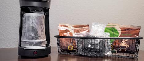 Een Hamilton Beach koffiezetapparaat voor commercieel gebruik en een mand met cafeïnevrije koffiecups en een plastic beker.