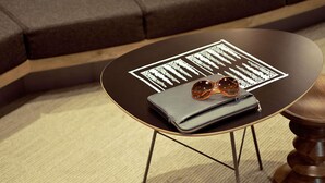 A round table with a black top and gold legs, a grey wallet, and a pair of sunglasses on top. - ibis Augsburg Hauptbahnhof (Augsburg)