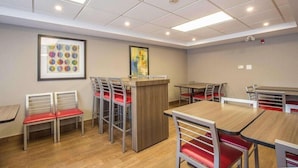 A modern dining area with a central counter, multiple tables, and chairs. - Comfort Inn Pickering (Pickering)